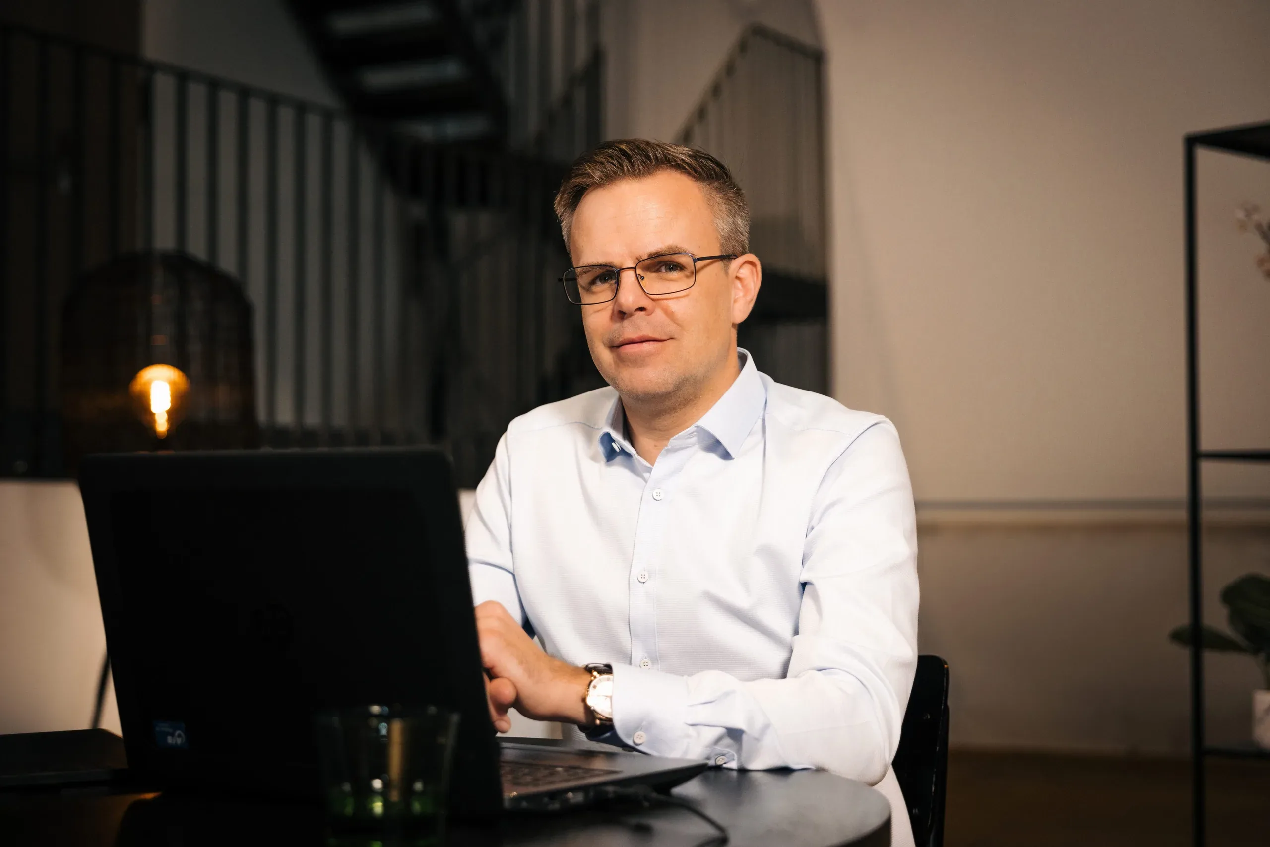 Finanzberater arbeitet am Laptop und analysiert Depots am Wohnzimmertisch