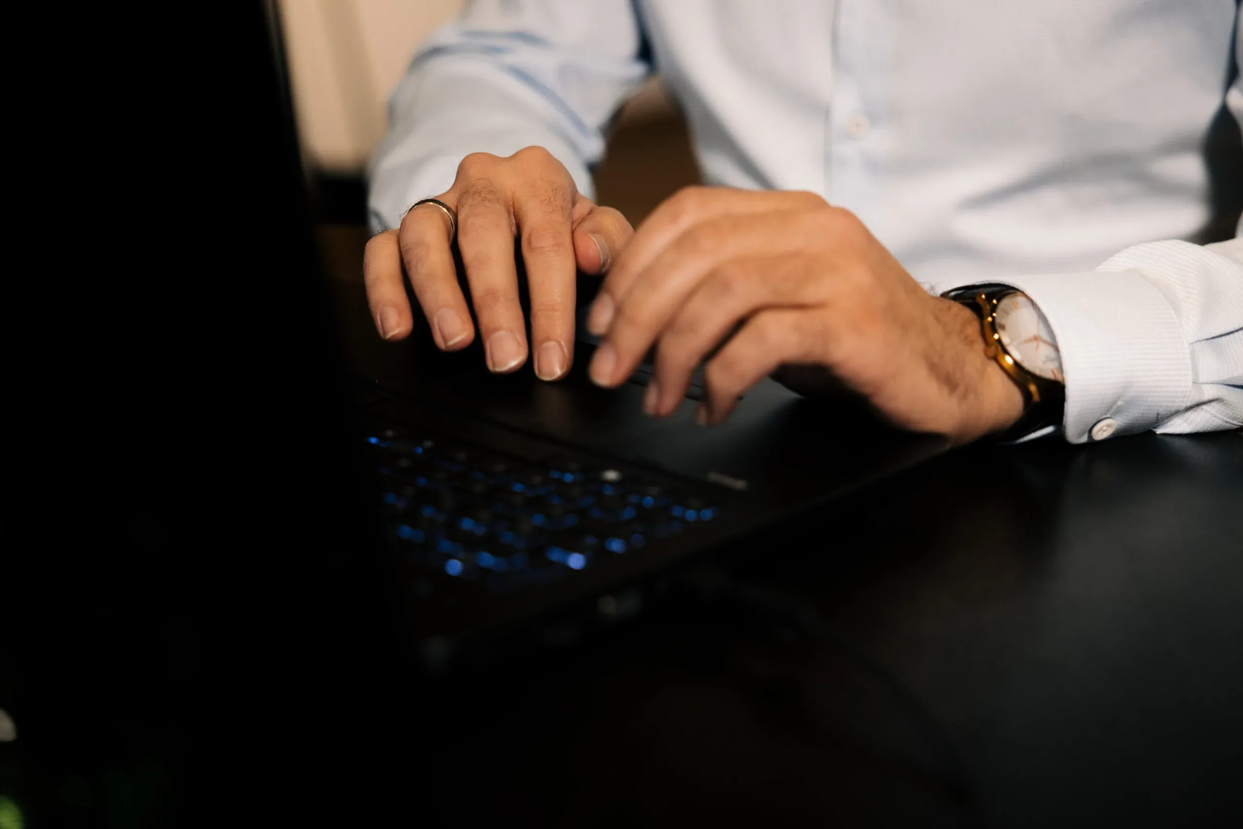 Nahaufnahme tippender Hände eines Beraters auf einer beleuchteten Tastatur