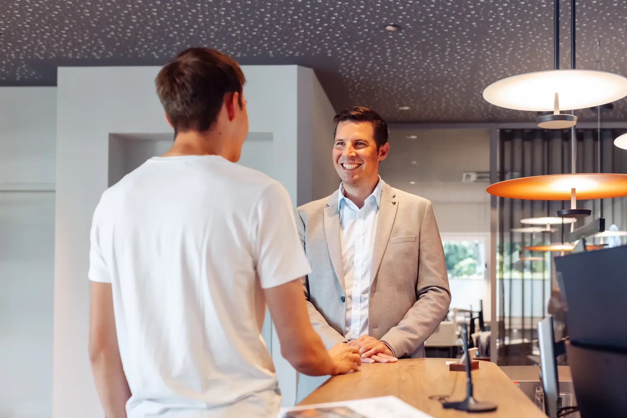 Michael Grasmann im Gespräch mit einem Kunden am Empfang