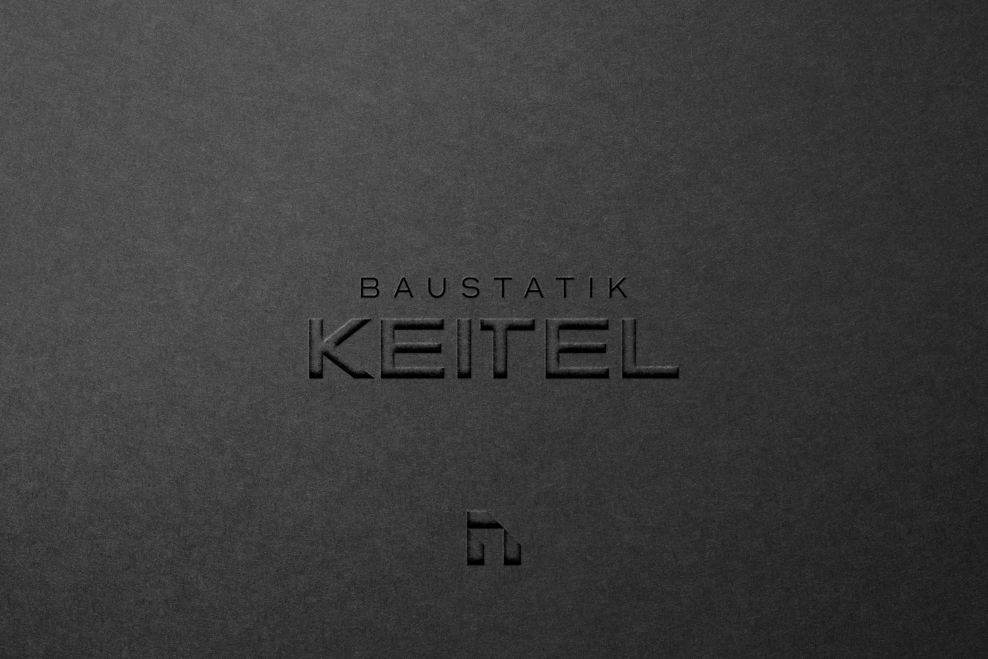 Blindprägung des Schriftzugs Baustatik Keitel auf dunklem Karton