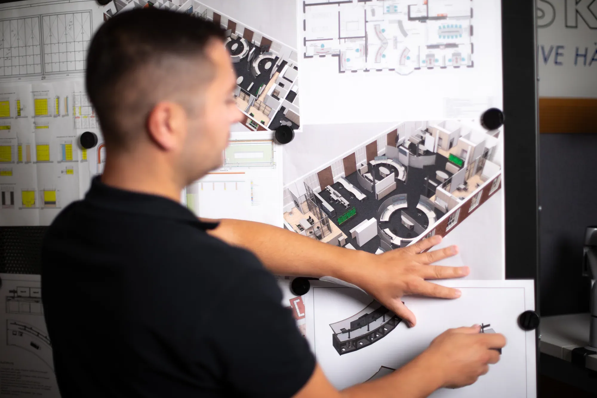 Konstrukteur heftet 3D-Entwürfe an die Planwand