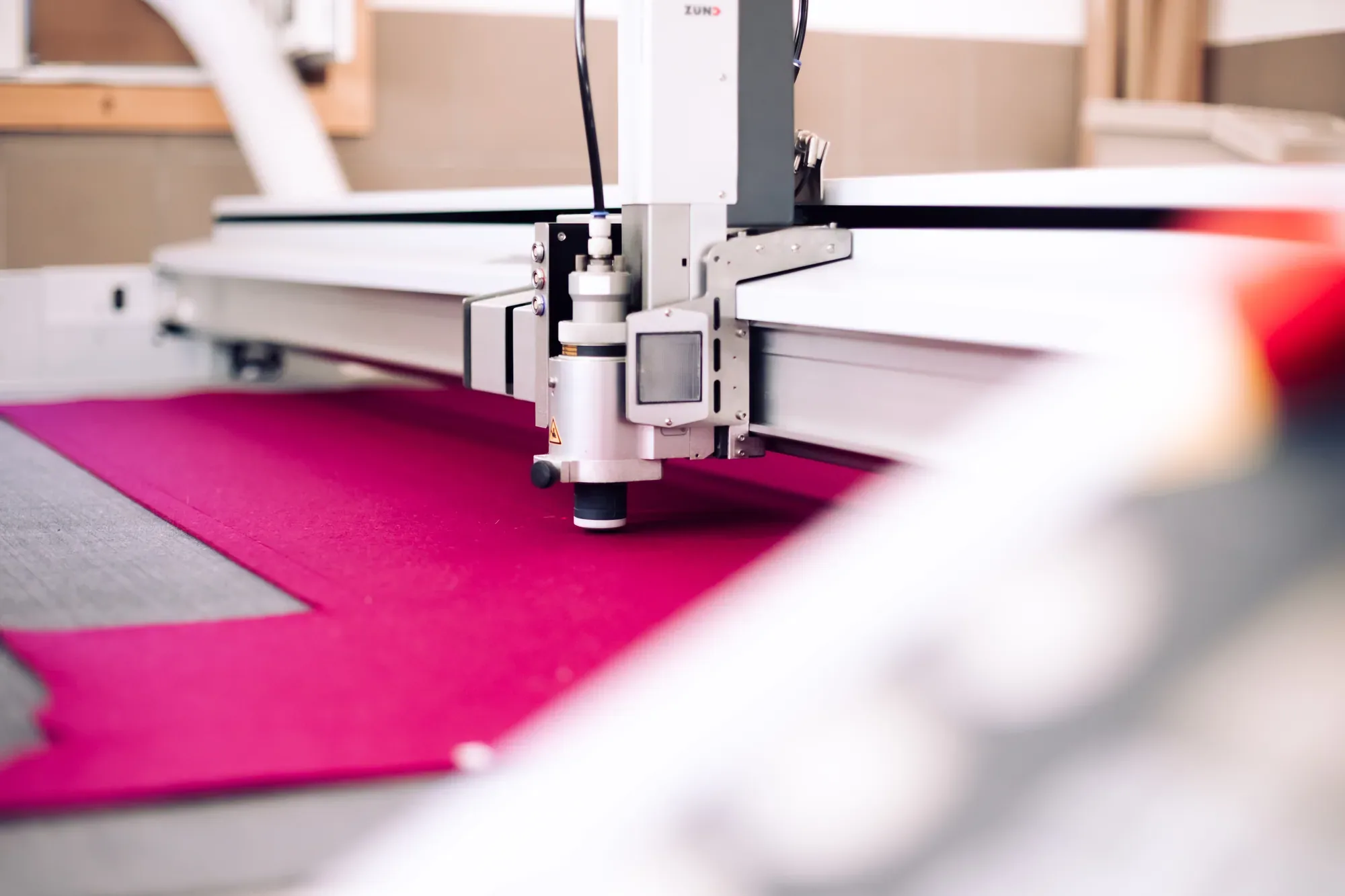 CNC-Schneidemaschine schneidet pinken Wollfilz zu