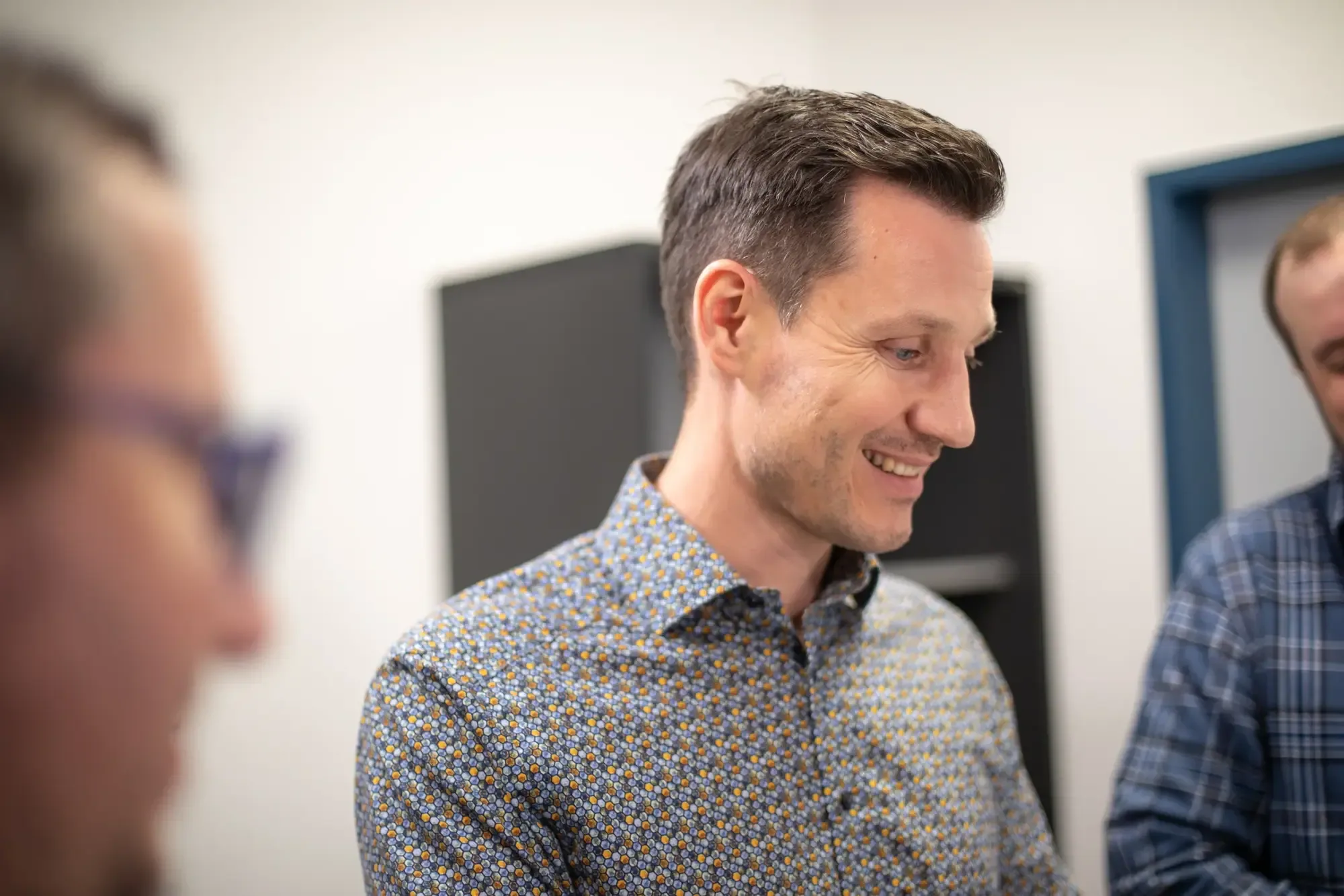 Christian Giefing lacht bei einer Besprechung im Büro