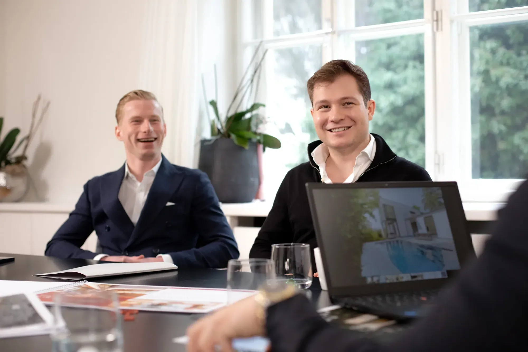 Die Brüder Greisberger lachen bei einer Besprechung am Tisch