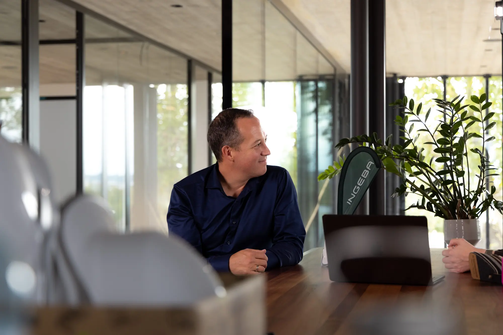 Robert Stürzlinger am Holztisch im neuen Büro beim Videodreh