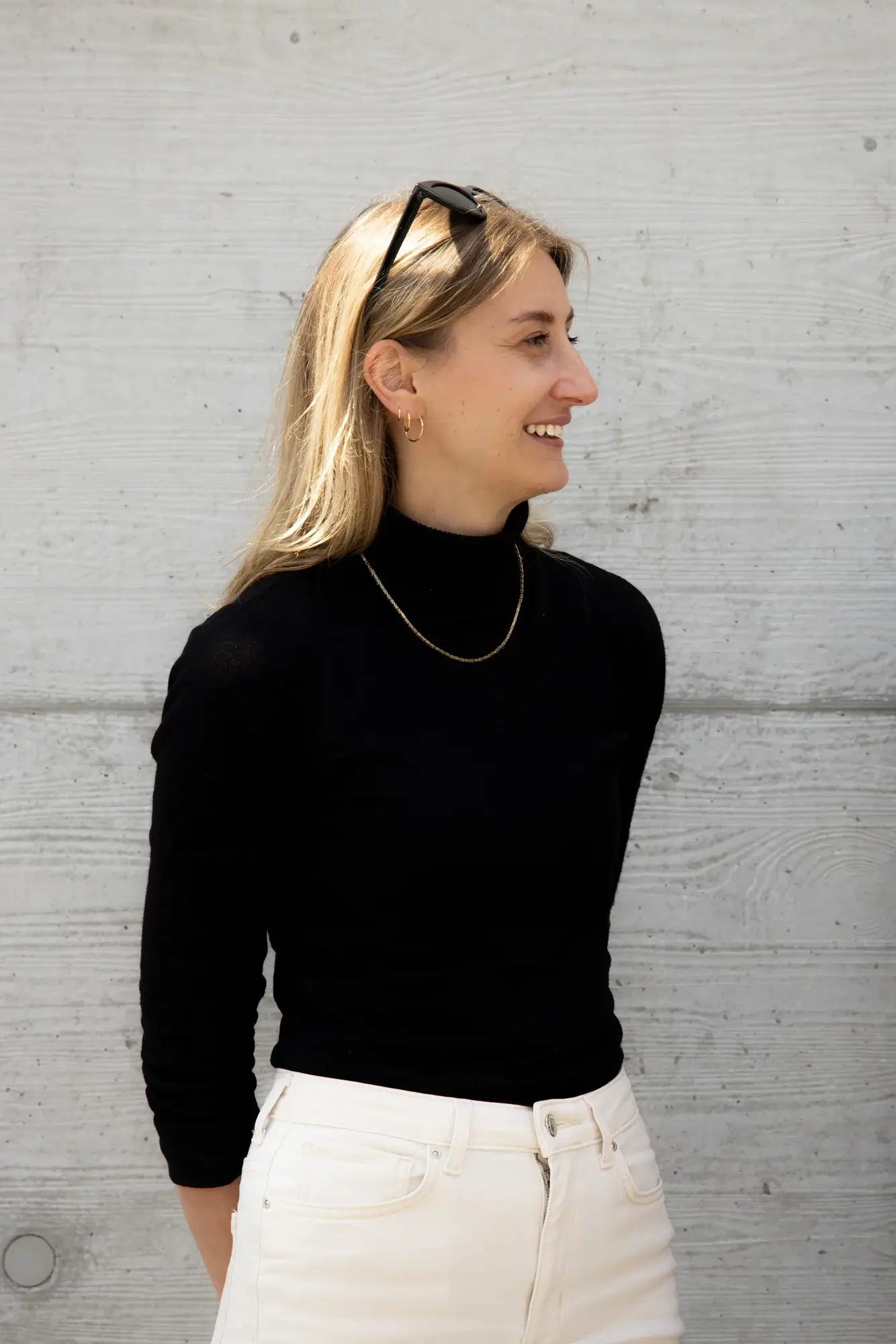Anna Prell lachend vor einer Sichtbetonwand
