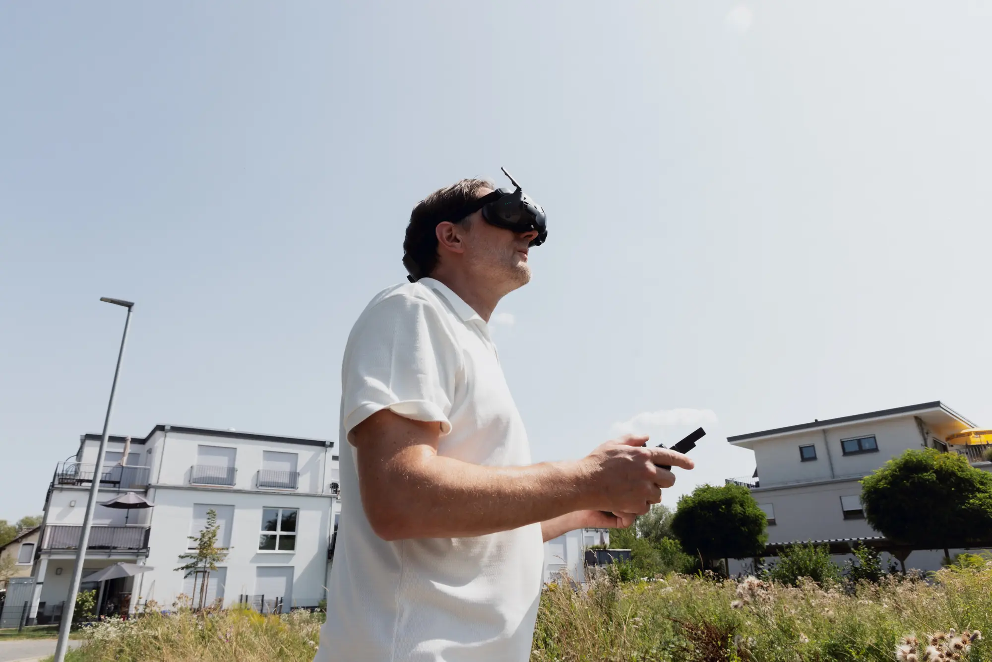 Architekt mit Videobrille steuert eine Drohne über ein Baugebiet