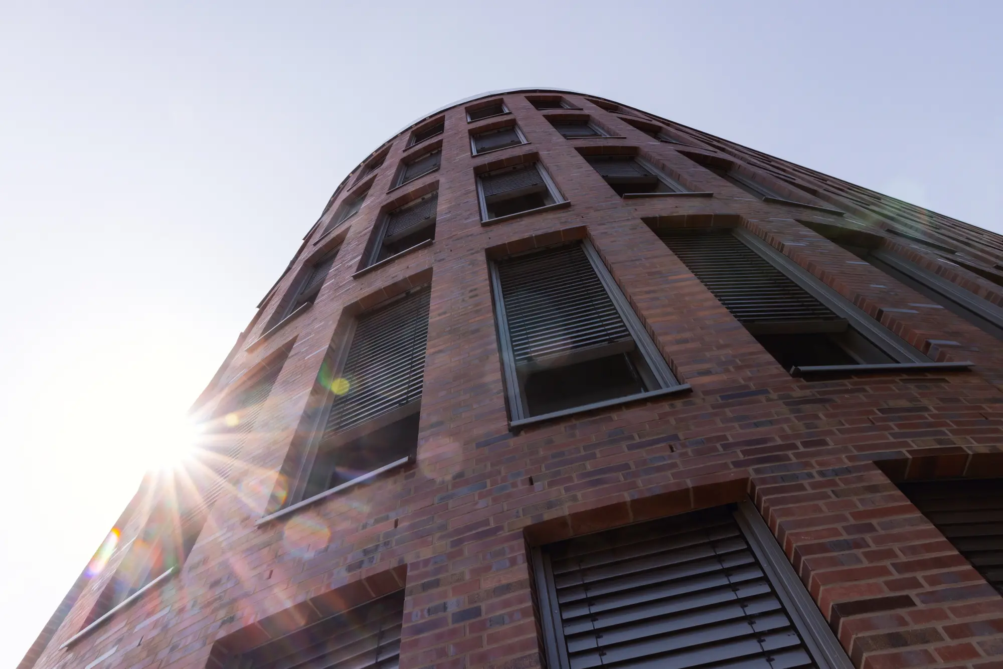 Runde Klinkerfassade eines Bürogebäudes gegen die Sonne