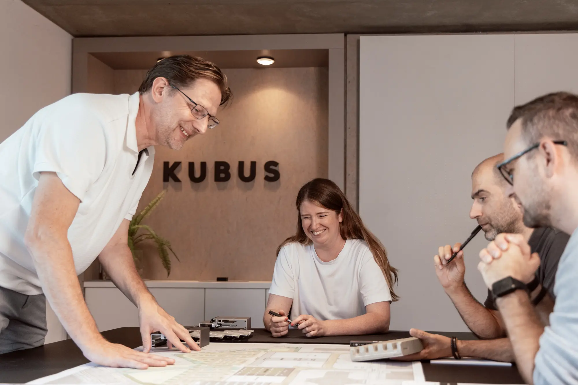 Team von KUBUS bespricht Pläne am großen Tisch