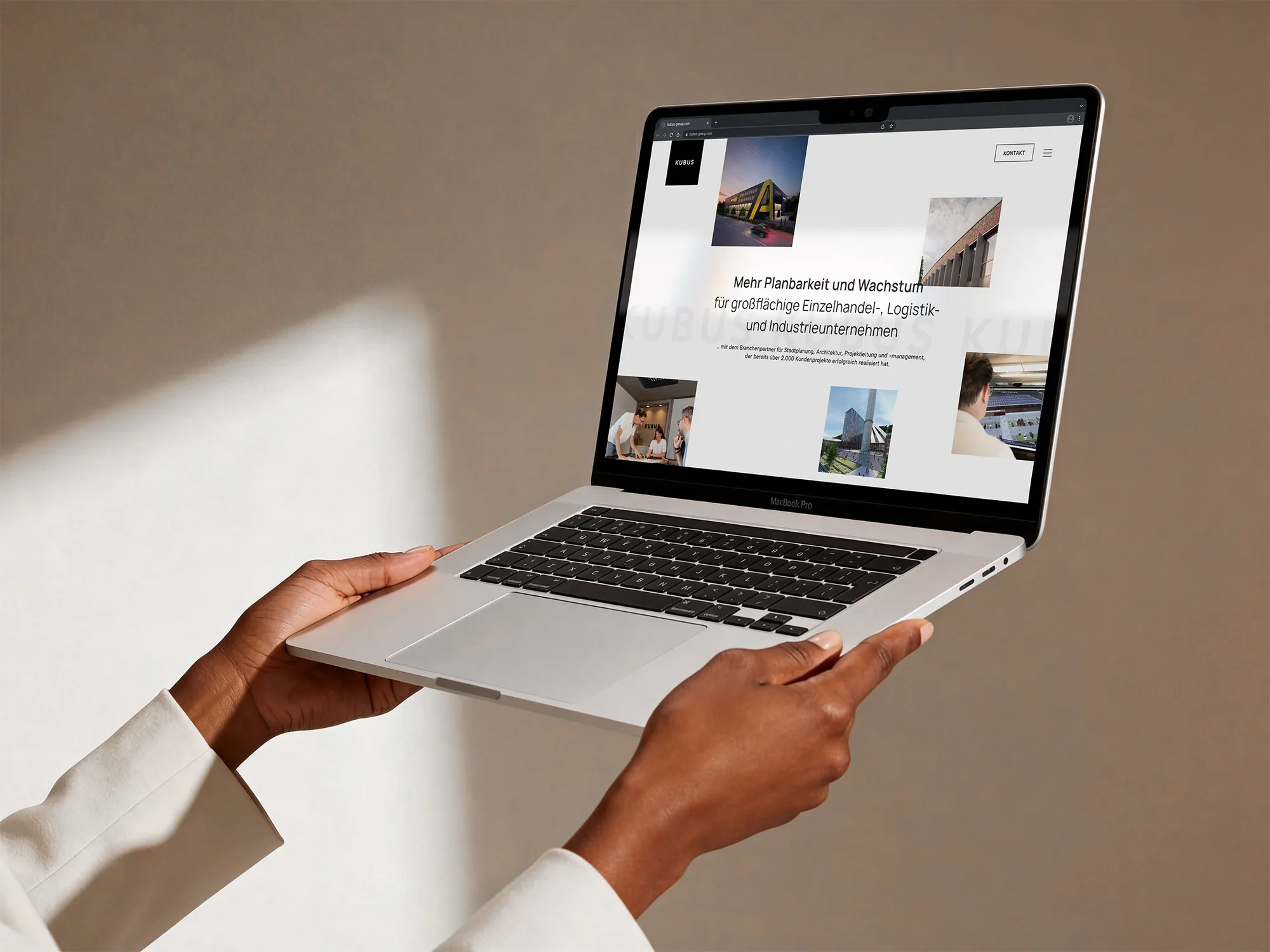 Laptop mit der Website von KUBUS in zwei Händen