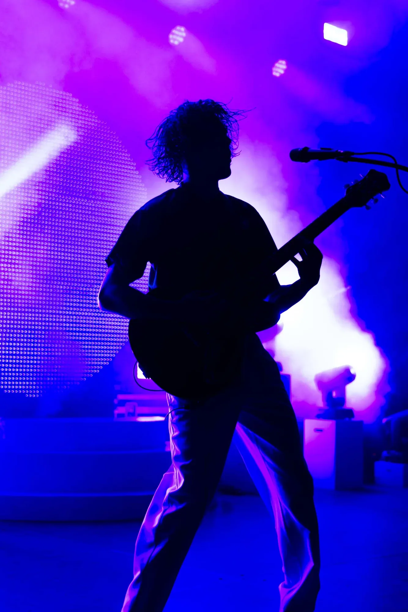 Gitarrist als Silhouette im violetten Bühnenlicht