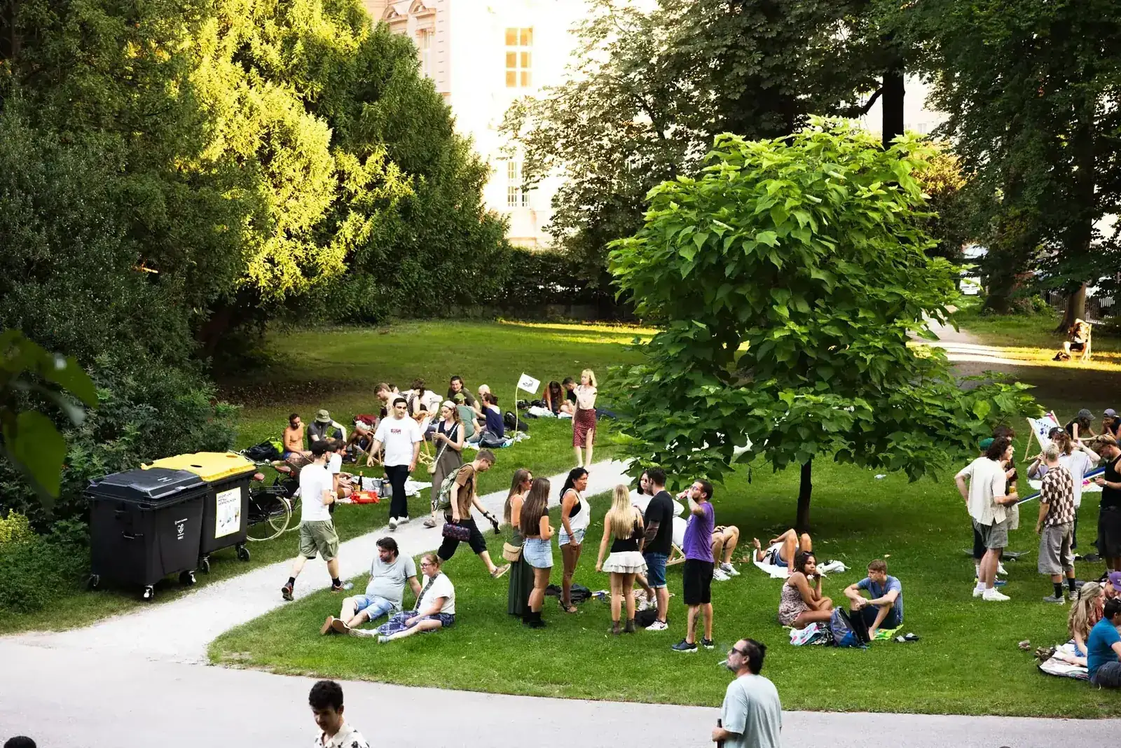 Gäste auf der Wiese im Park bei einem DJ-Pop-up am Nachmittag