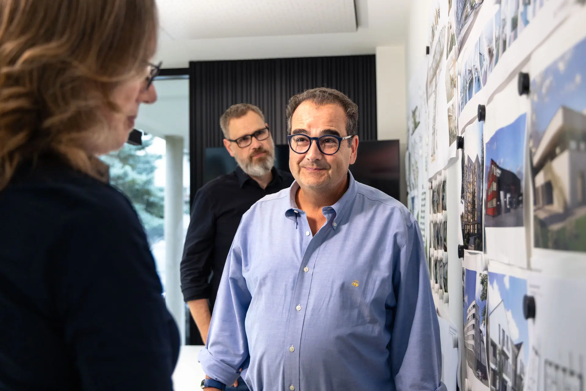 Bauherr und Architekten vor der Projektwand im Büro von Main Werk