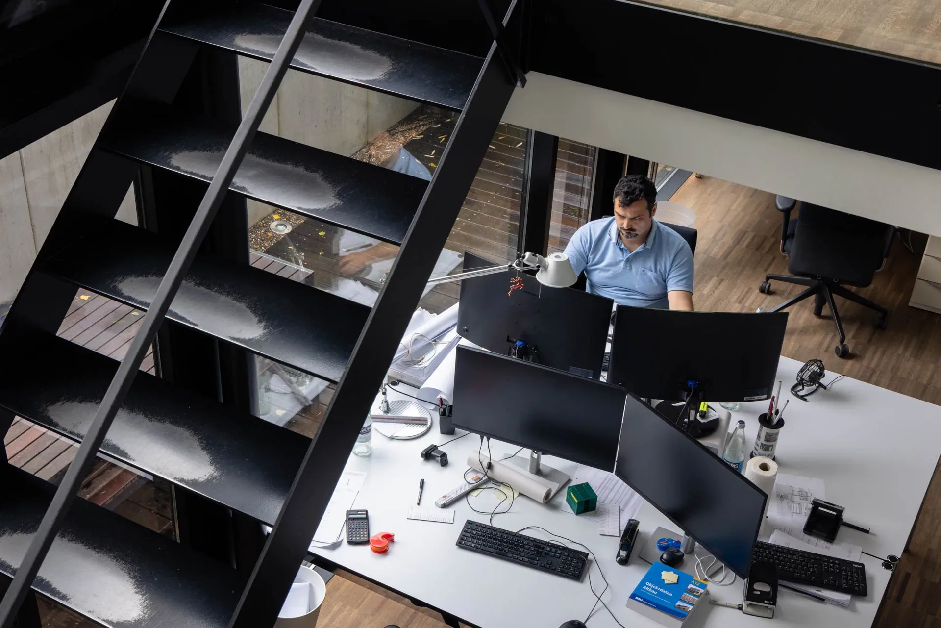 Blick von der Treppe auf einen Arbeitsplatz im Büro von Main Werk