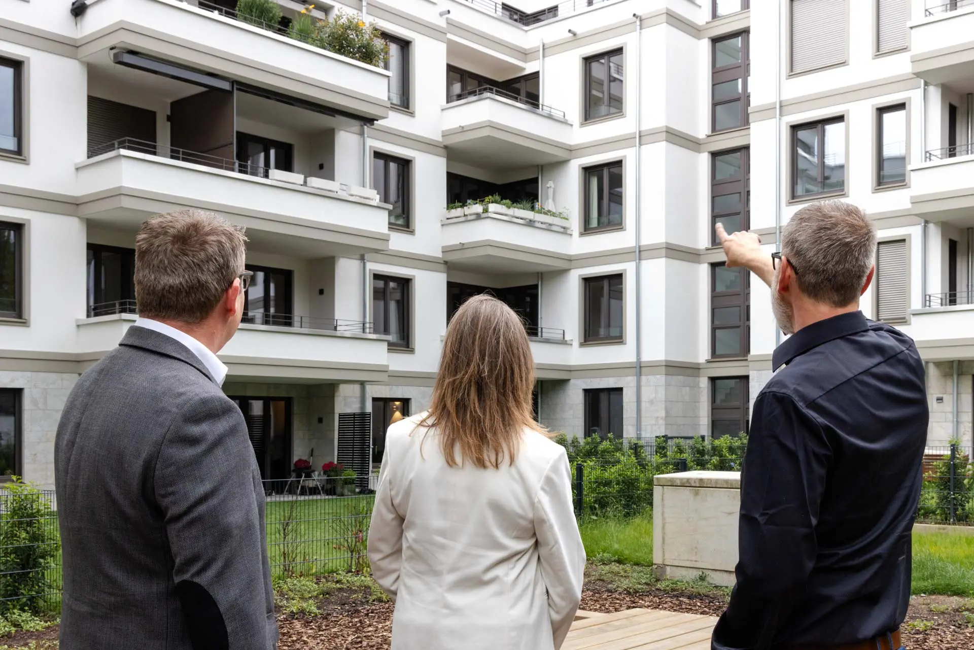 Geschäftsführung von Main Werk mit einem Bauherrn vor dem fertigen Wohnhaus