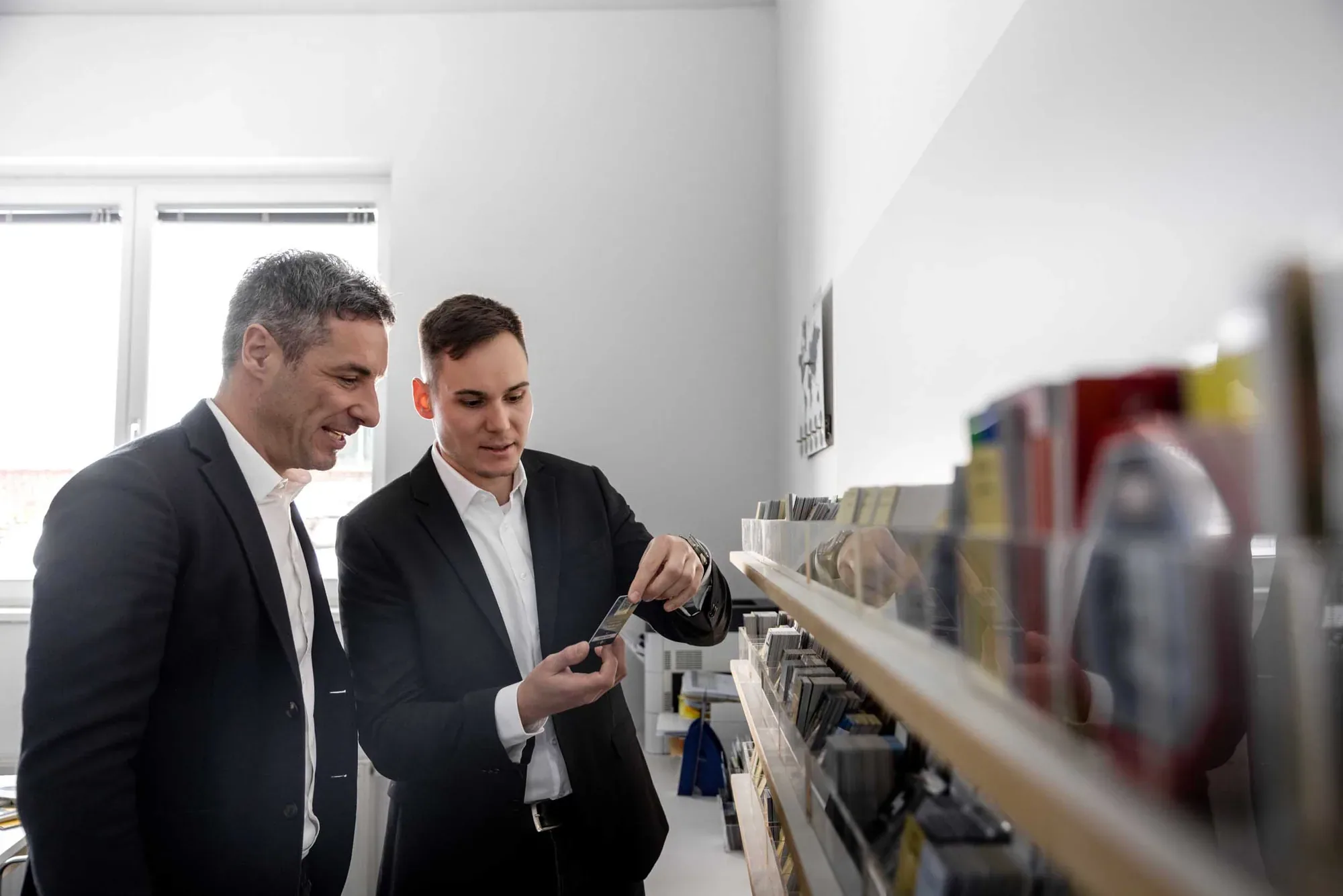 Andreas Maier und Lukas Dörrich prüfen Kartenmuster am Regal
