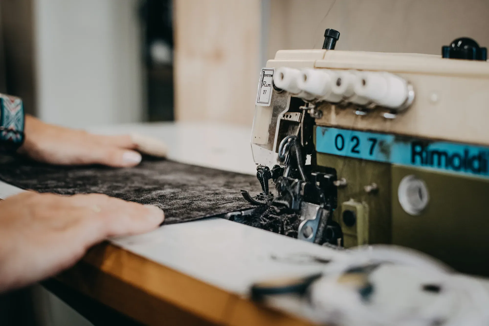 Hände an der Overlock-Maschine in der Polsterei