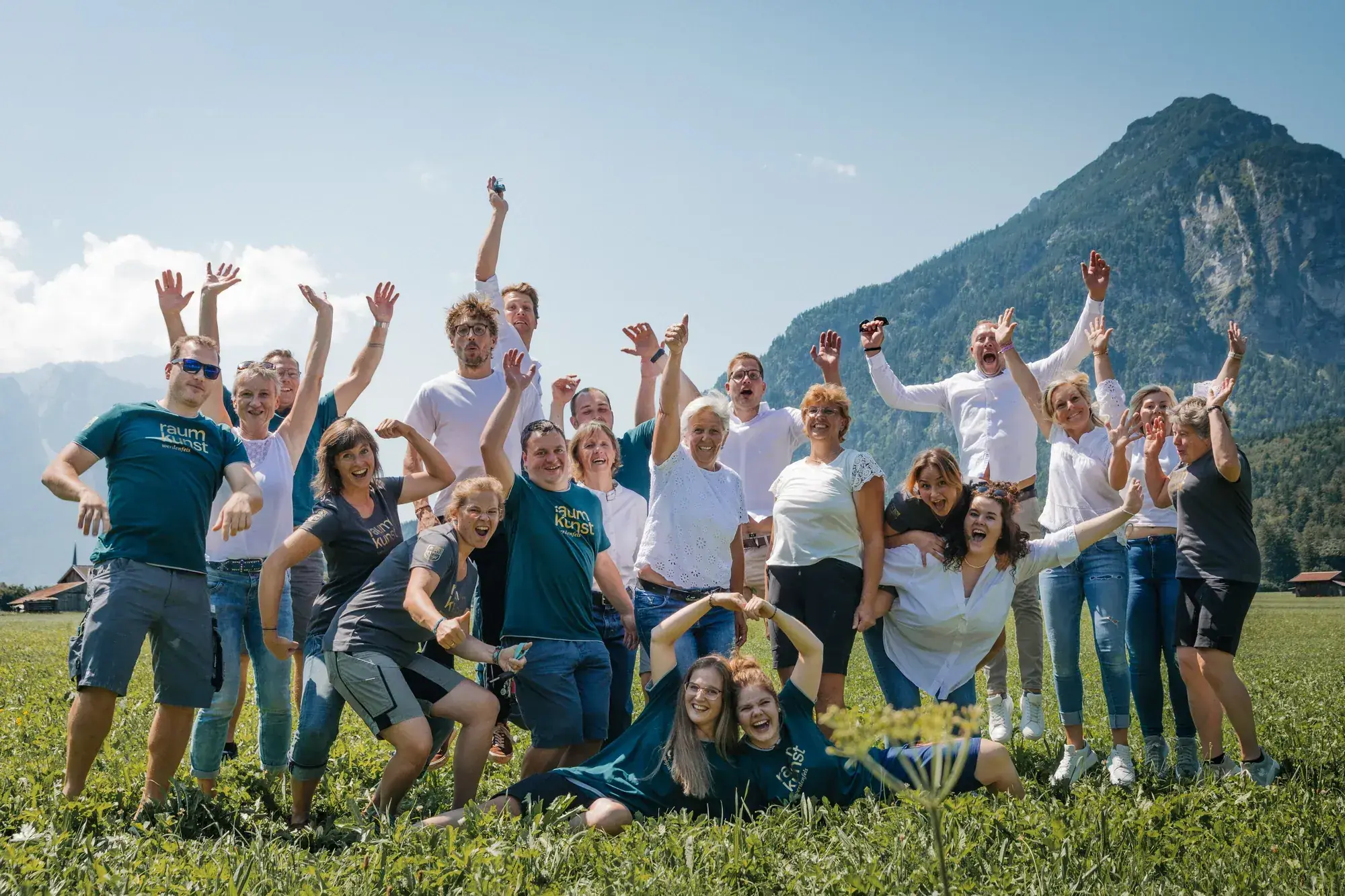 Das Team von Raumkunst Werdenfels auf einer Wiese vor den Bergen