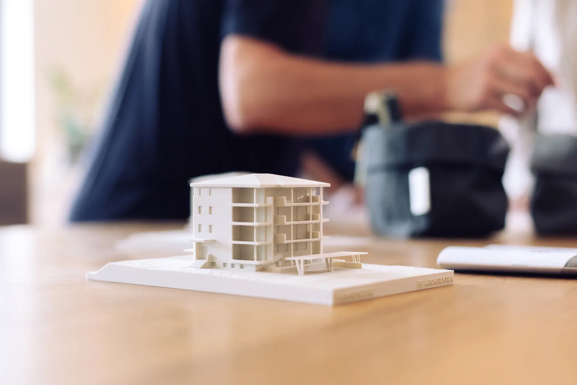 Weißes Architekturmodell auf einem Holztisch