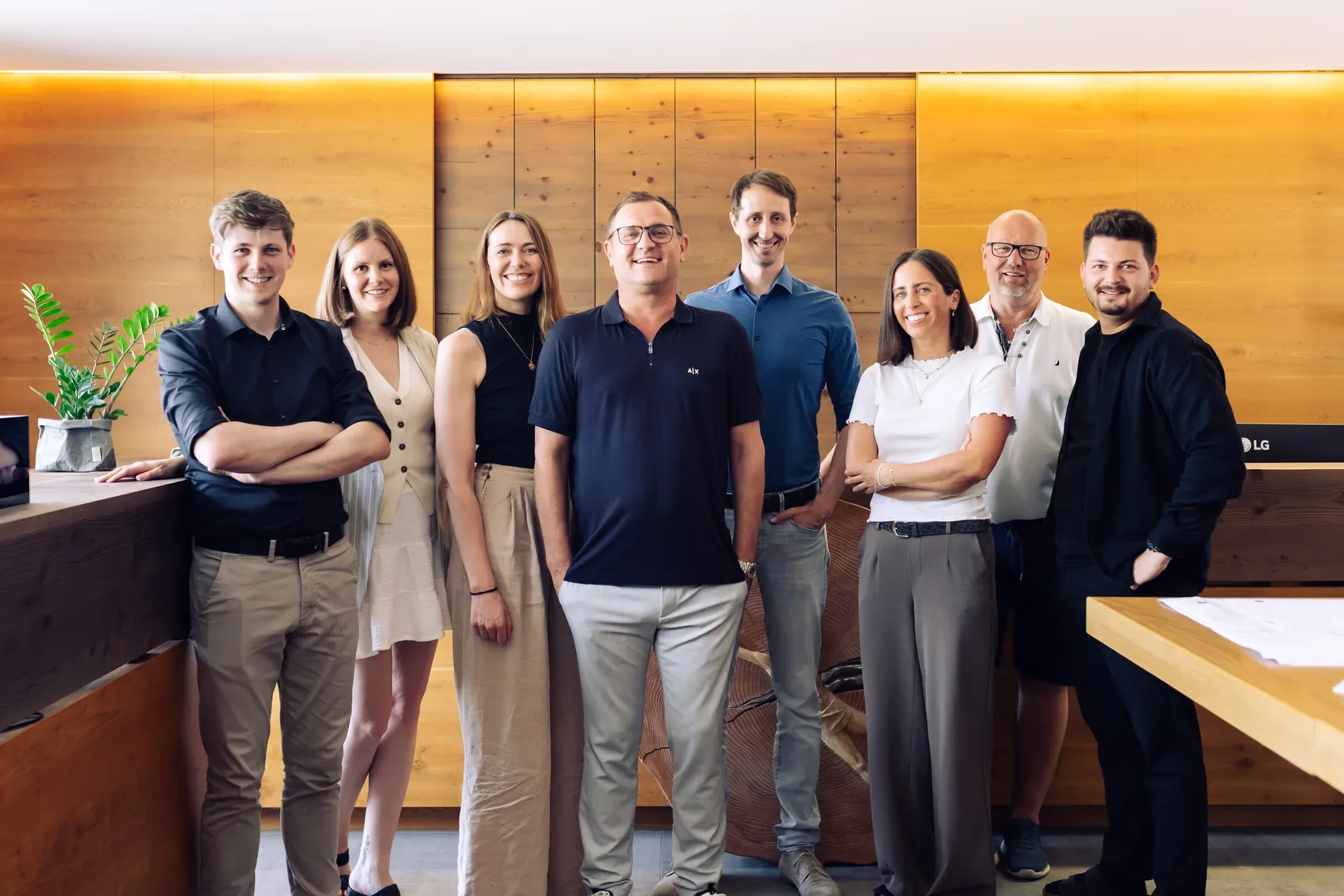 Das Team von RP Architektur vor der Holzwand im Büro