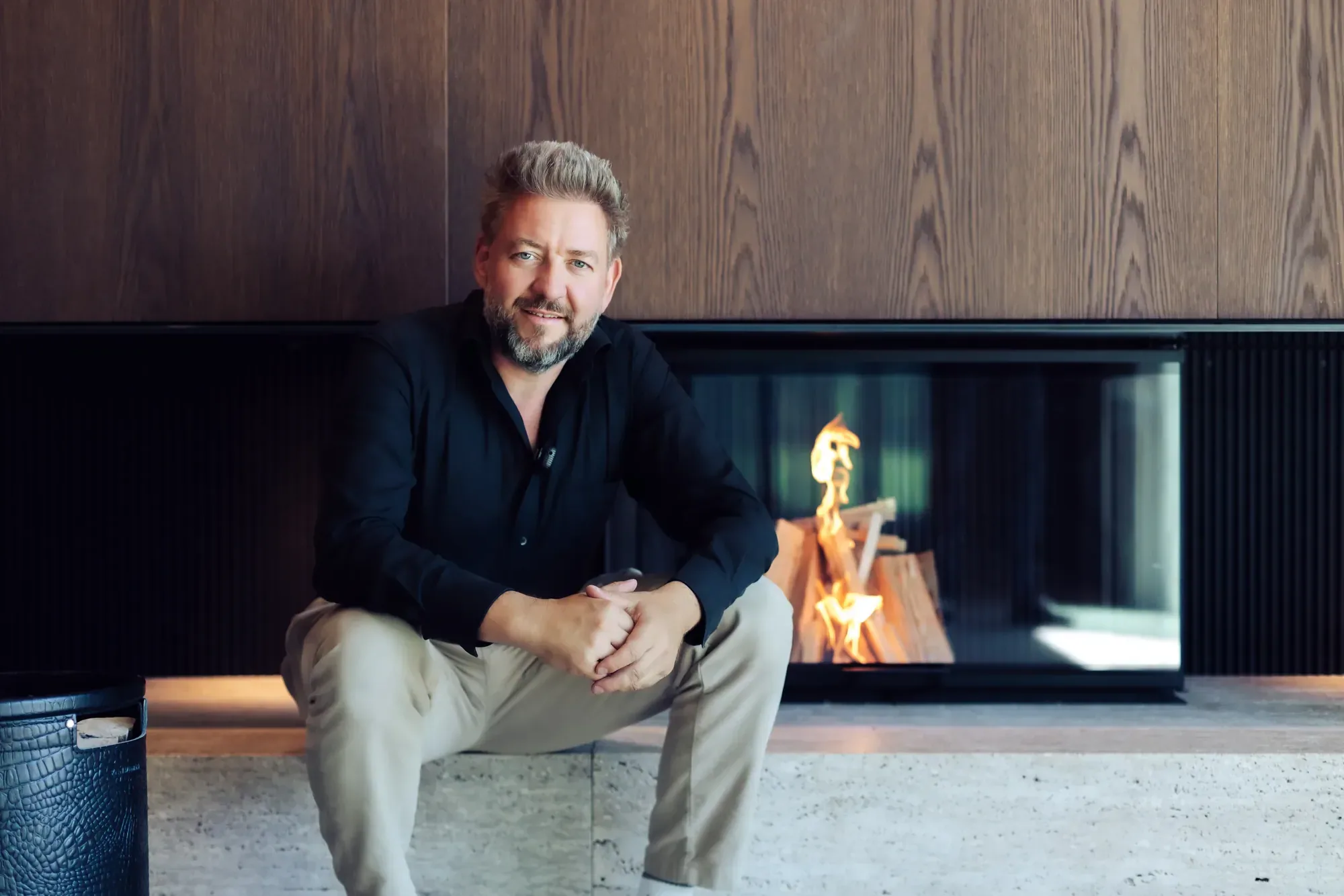 Stefan Schinharl sitzt vor einem Kamin im Showroom in Landshut