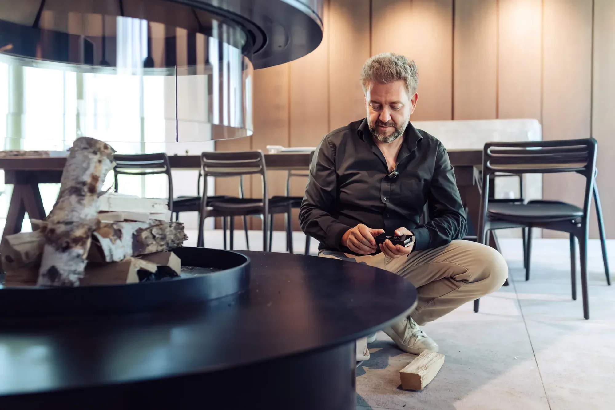 Stefan Schinharl entzündet das Feuer an einer offenen Feuerstelle im Showroom