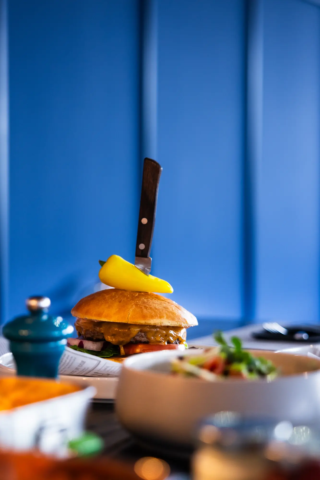 Burger mit Salat vor der blauen Wand im Restaurant