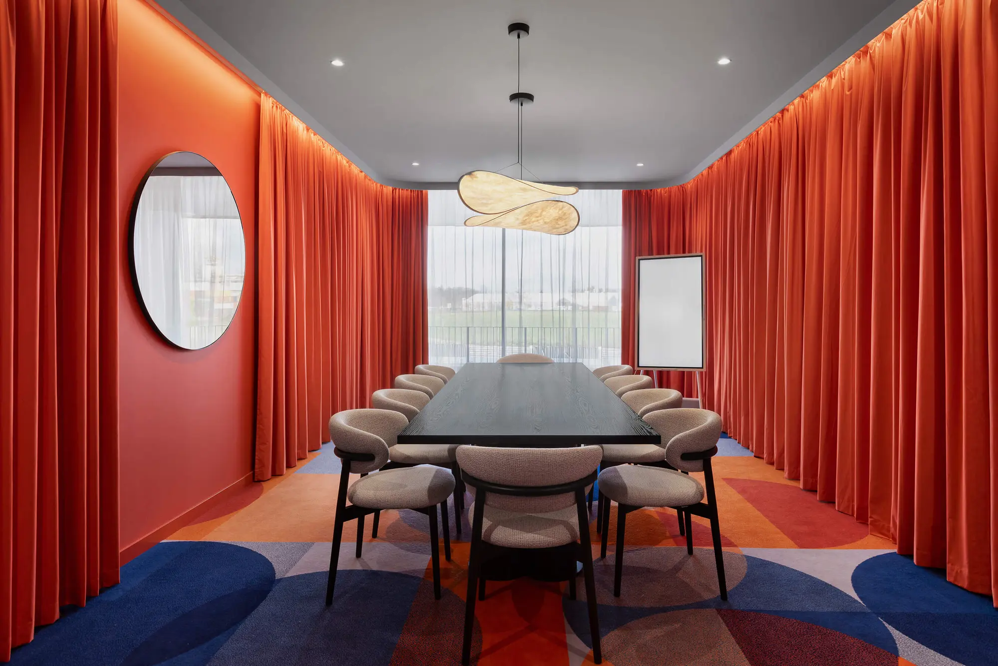 Secret Room mit langer Tafel, roten Vorhängen und gemustertem Teppich