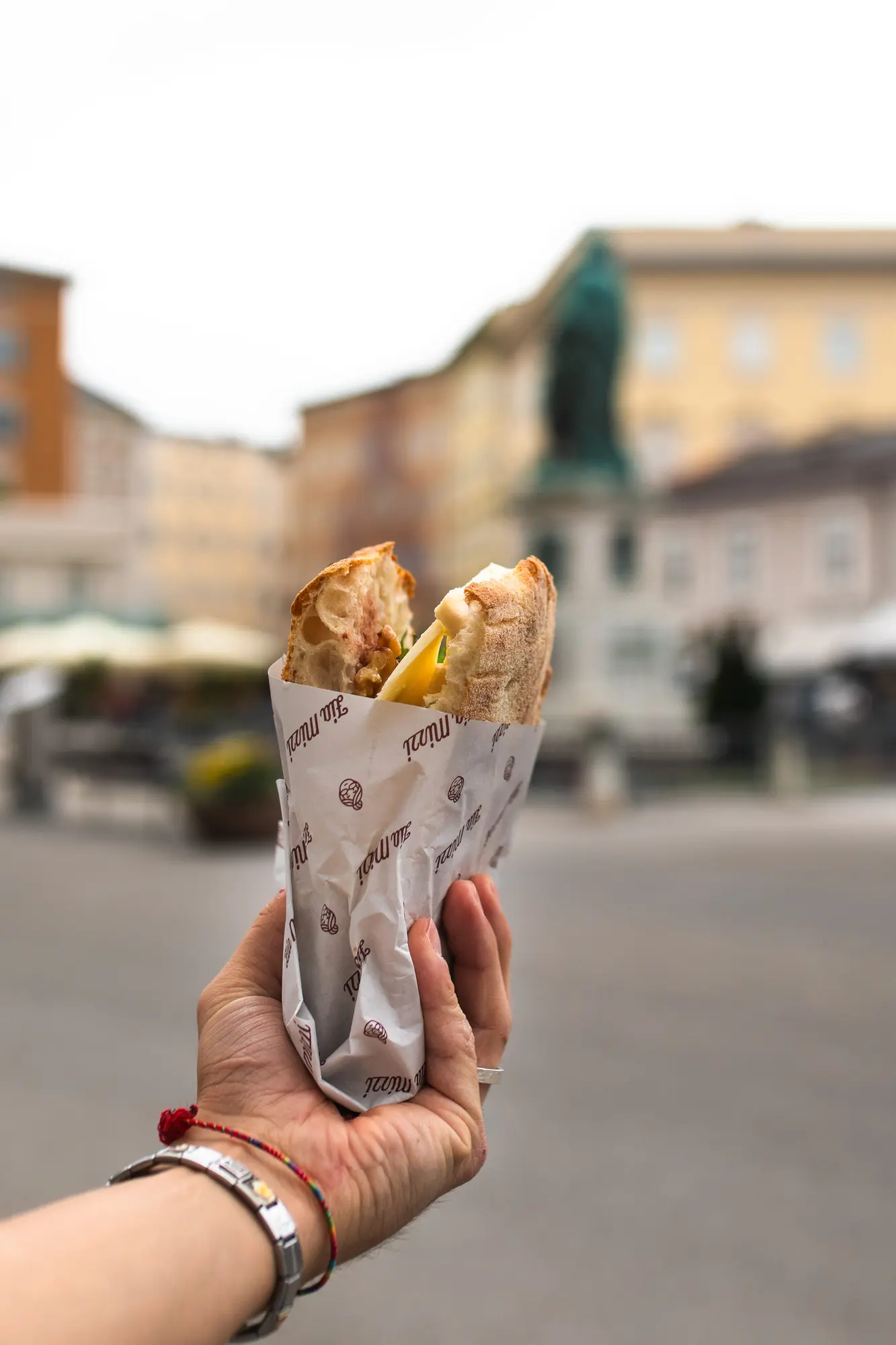 Focaccia im bedruckten Wickelpapier vor dem Mozartdenkmal