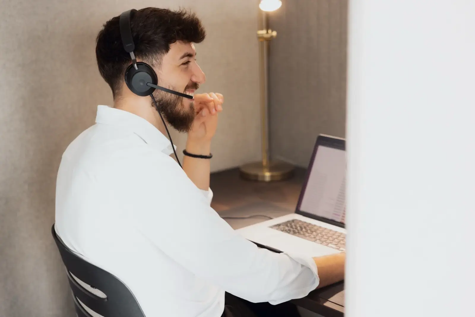 Ein Kollege von Martin&Klein telefoniert mit Headset am Arbeitsplatz