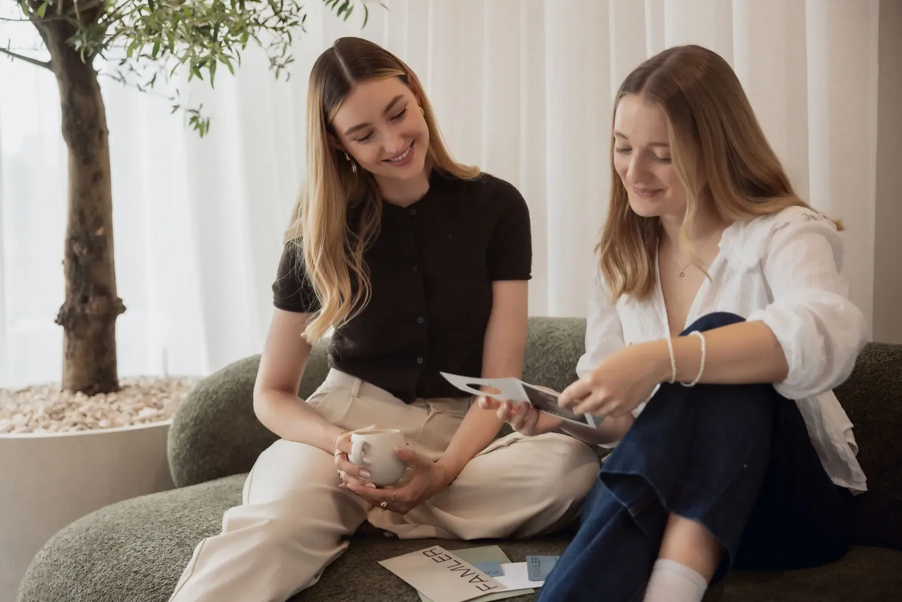 Zwei Kolleginnen von Martin&Klein besprechen Entwürfe auf dem Sofa