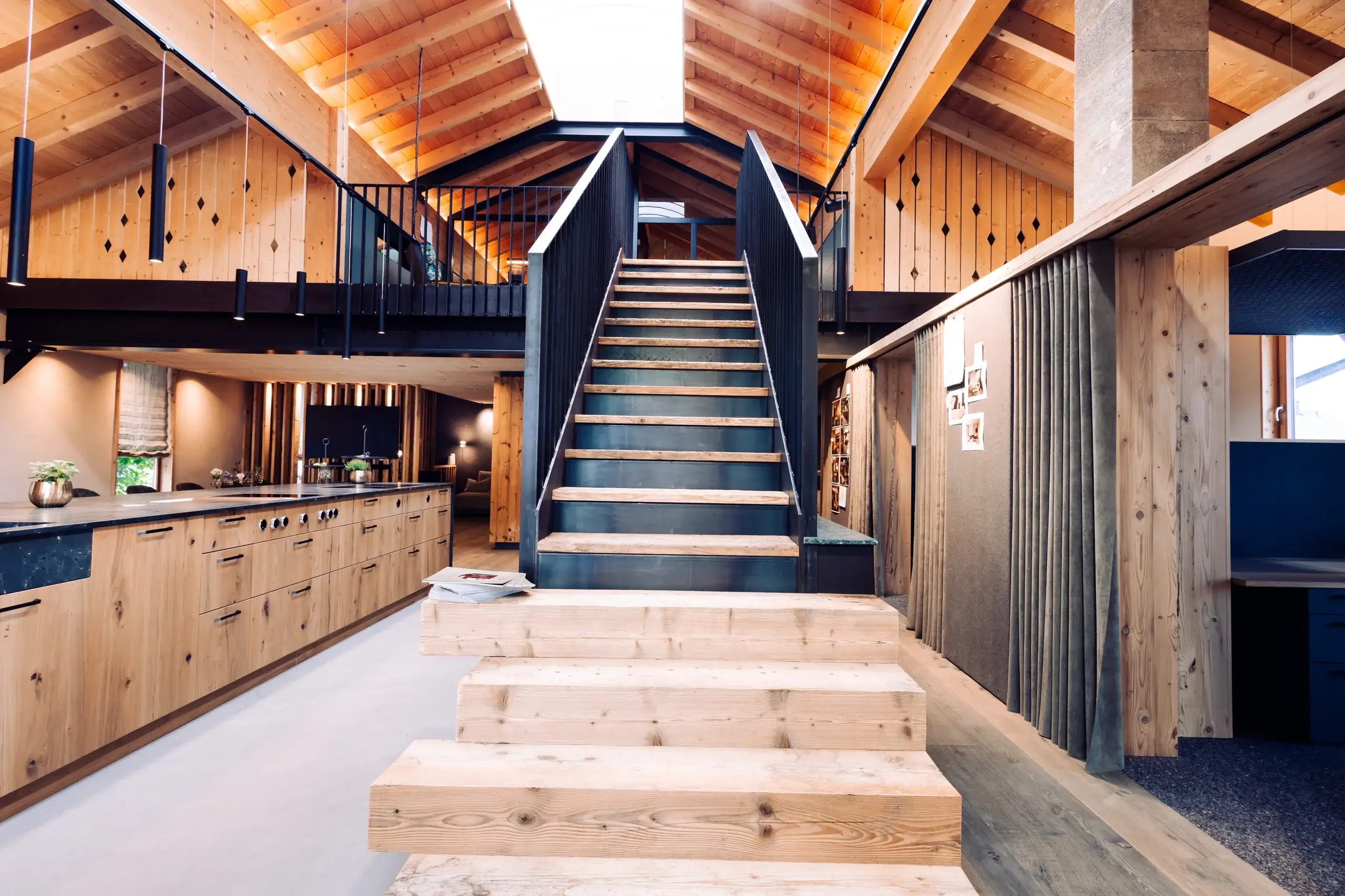 Holztreppe zur Galerie zwischen Küche und Ausstellungsfläche