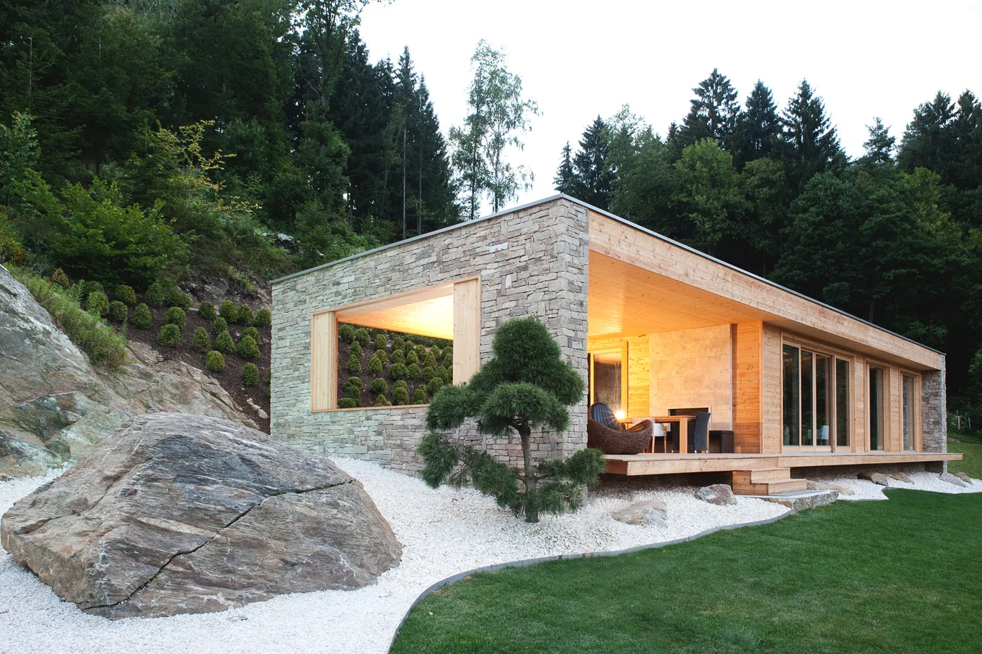 EFH Millstätter See — Natursteinhaus mit überdachter Holzterrasse am Hang