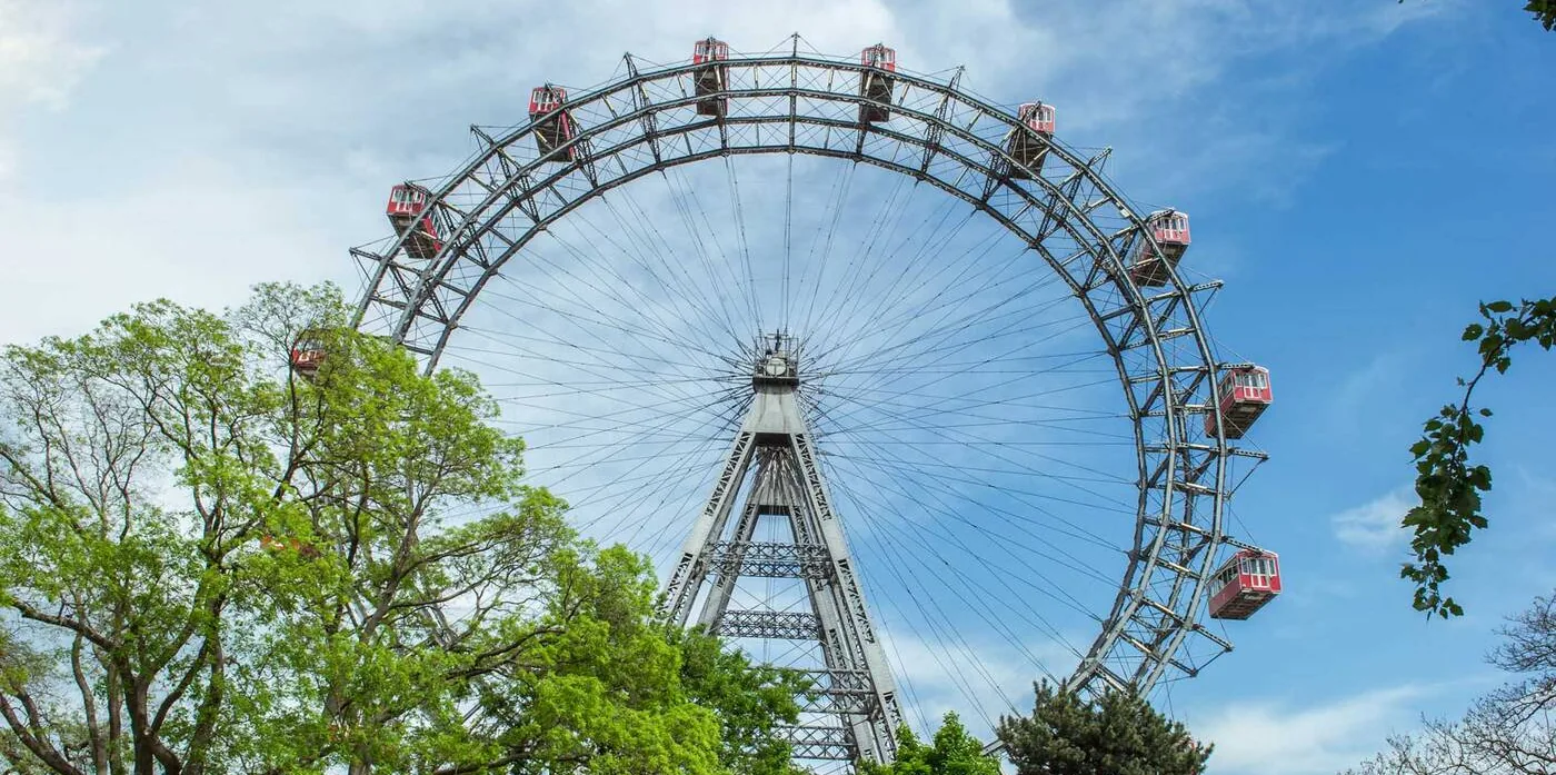 Wiener Riesenrad Revitalisierung — das ganze Rad mit roten Waggons über den Bäumen des Praters