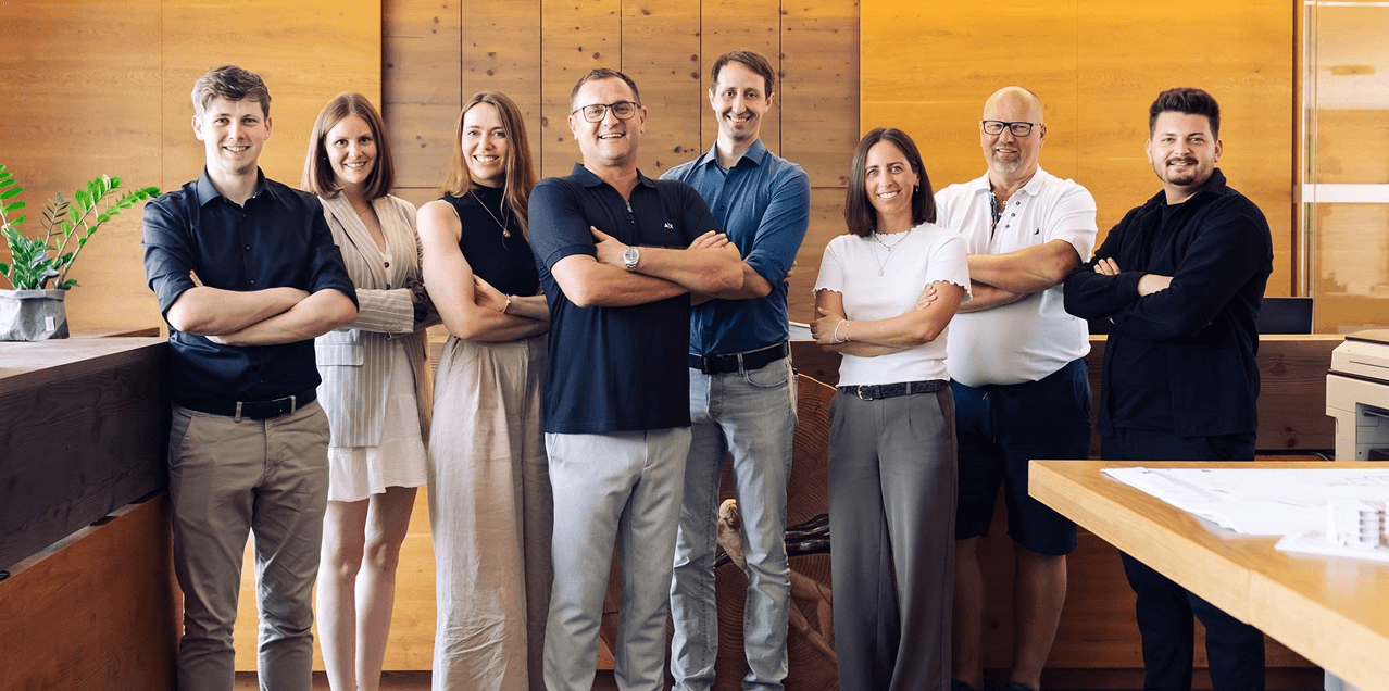 Das Team von RP Architektur & Design vor der Holzwand im Büro